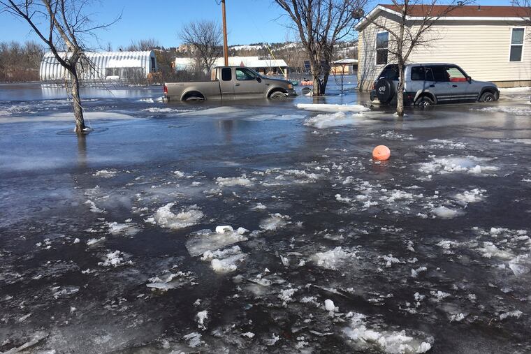 This March 2019 photo provided by Henry Red Cloud, shows flooding on Cloud's Lakota Solar Enterprises property on the Pine Ridge Reservation in southern South Dakota. Red Cloud estimates flood damage at $250,000. Plains and Midwest states are bracing for another massive winter storm Wednesday and Thursday and the prospect of renewed flooding when the snow melts. (Henry Red Cloud via AP)
