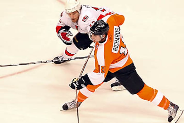 Flyers' Mike Richards takes a shot on goal against Senators' Mike Fisher during the 3rd period at the Wachovia Center in Philadelphia, Thursday, November. 12, 2009. Flyers beat the Senators 5-1. ( Steven M. Falk / Staff Photographer )