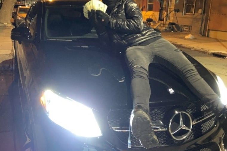 Prosecutors in Chester County say this picture depicts Louis Mendoza posing with a Mercedes and cash stolen from a home in Eassttown Township in January. Mendoza and two other men have been charged with holding the couple who live in that home at gunpoint during the burglary.