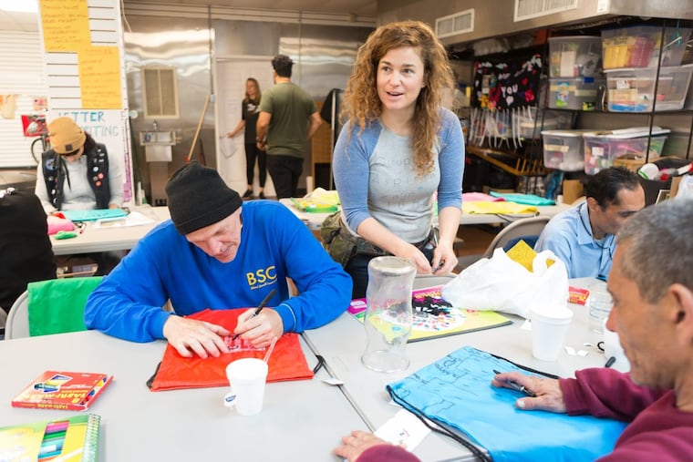 Callie Curry, a/k/a Swoon, works with people at the Mural Arts Kensington Storefront.