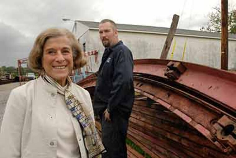 Barbara Cohen and Sam Trotter with a section of the disassembled Phoenix wheel at Quality Counts Welding in Kimberton, near Phoenixville. With some financial assistance, she bought the wheel and brought it back from Asbury Park, N.J.