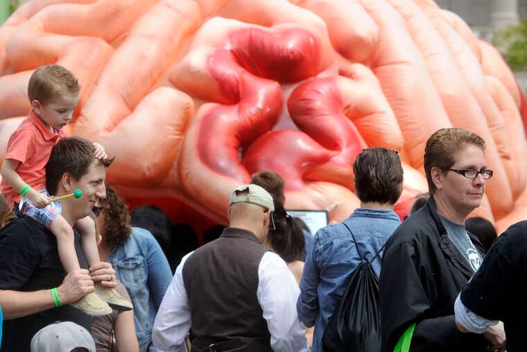 The incredible gigantic invading brain? No, a cool walk-through inflatable passed by Bennett Duffin, 3, on the shoulders of his dad, Bryan, of Upper Darby, at the Philadelphia Science Festival carnival on the Parkway.