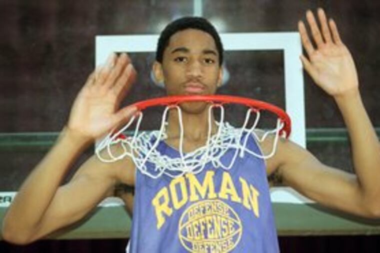 Eddie Griffin poses in the basket at Roman Catholic High School. The Inquirer named him player of the year in 2000. He went on to a checkered five-year career in the NBA.