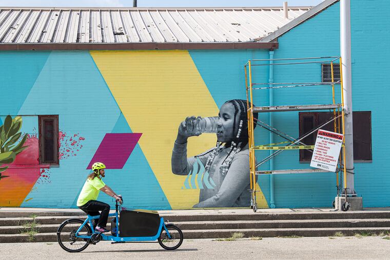 Drink More Tap, diseñado por el artista salvadoreño CALO Rosa, en el Centro de Recreación Narcisa Cruz. El mural presenta imágenes de residentes locales y aborda la desconfianza de la comunidad en el agua de la pluma.