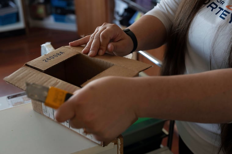 Amanda Follett opens packages at A Sight For Sport Eyes, a brick-and-mortar and e-commerce store for sport goggles, in West Linn, Ore., Aug. 20, 2025.