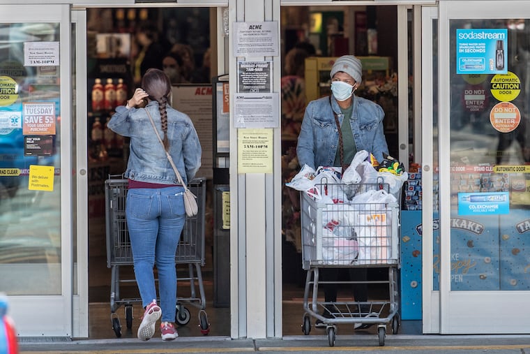 Customers entering and exiting the Acme grocery store on Ridge Avenue in Roxborough wear masks in April. The CDC recently recommended returning to indoor masking after relaxing those guidelines in May.
