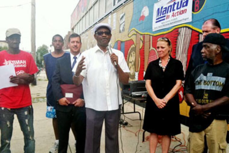 The Rev. Andrew Jenkins (center) and other members of the group Mantua Community Planners announce their lawsuit against the city and Councilwoman Blackwell. JAN RANSOM / Staff