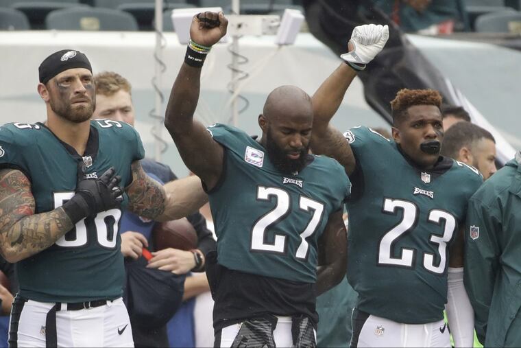 Philadelphia Eagles' Chris Long (56), Malcolm Jenkins (27) and Rodney McLeod (23) gesture during the National Anthem before an NFL football game against the Arizona Cardinals, Sunday, Oct. 8, 2017, in Philadelphia. (AP Photo/Matt Rourke)