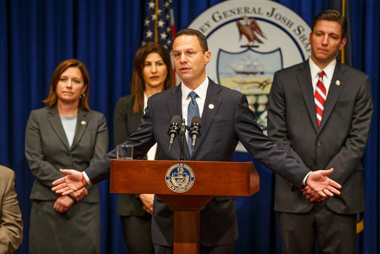 Pennsylvania Attorney General Josh Shapiro gestures with his outstretched arms that the victims seated on the stage with him were the real heros of the Grand Jury Report on Child Sexual Abuse in six Catholic Dioceses in Pennsylvania at the State Capital on August 14, 2018. MICHAEL BRYANT / Staff Photographer