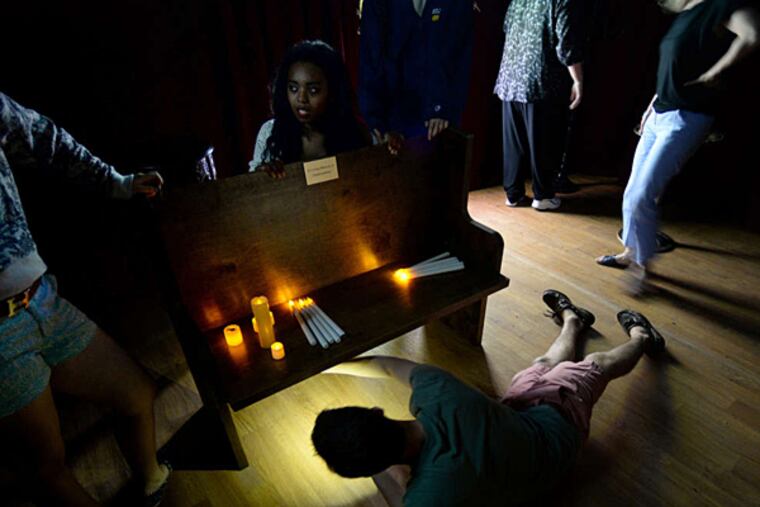 Gamers search for clues to get out in a session at Escape the Room Philly. (TOM GRALISH / Staff Photographer)