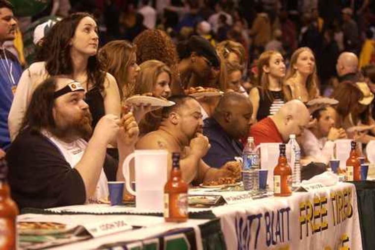 Damaging Doug (left), Chili Dog (middle) and Eric "Badlands" Booker compete in Wing Bowl 12 in 2004 at the Wachovia Center.