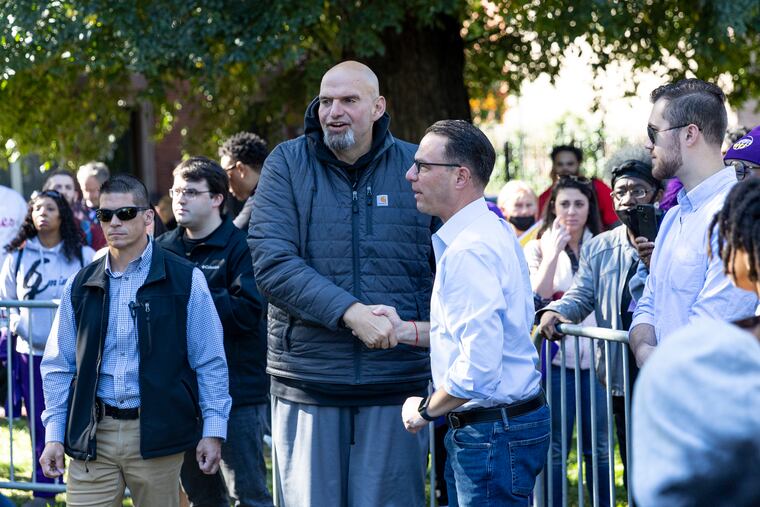 Attorney General Josh Shapiro (center right) and Lt. Gov. John Fetterman greeting each other at Norris Square Park in Philadelphia on Oct. 15.