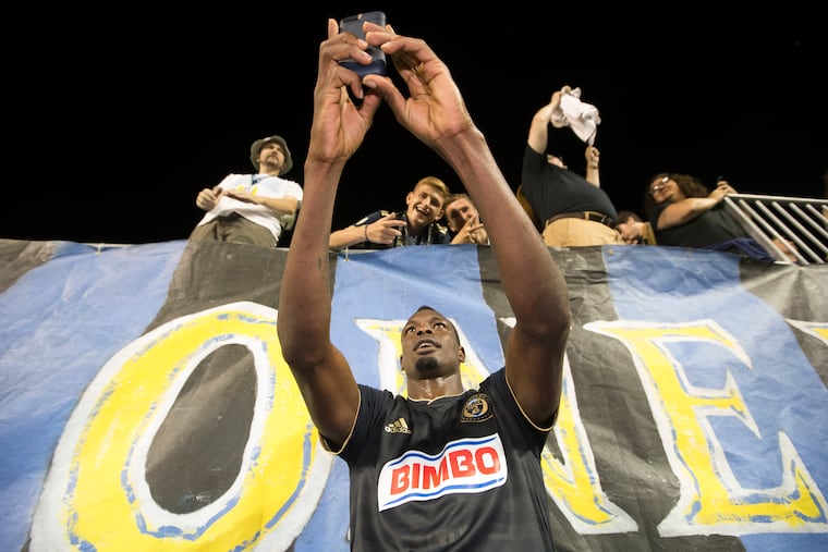 Union striker Cory Burke poses for a photo with some fans after a game earlier this season.