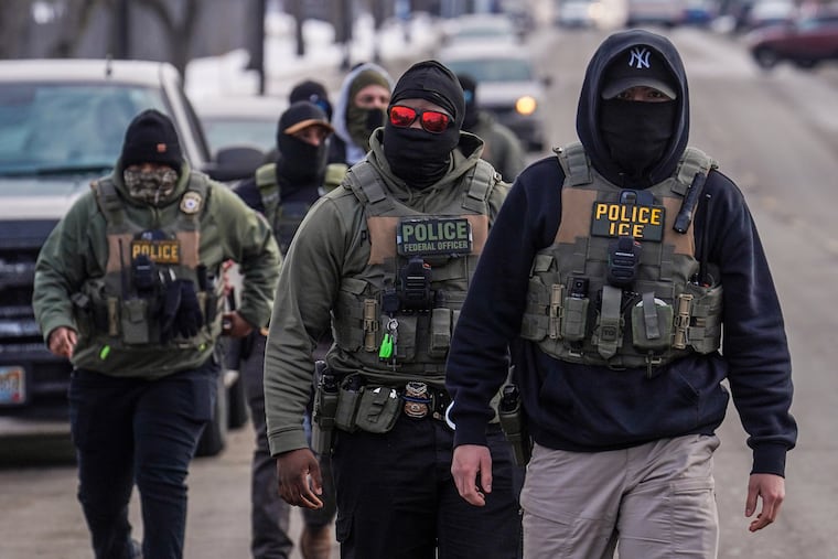 Federal agents walk down a street on Feb. 5 while conducting immigration enforcement operations in Minneapolis.