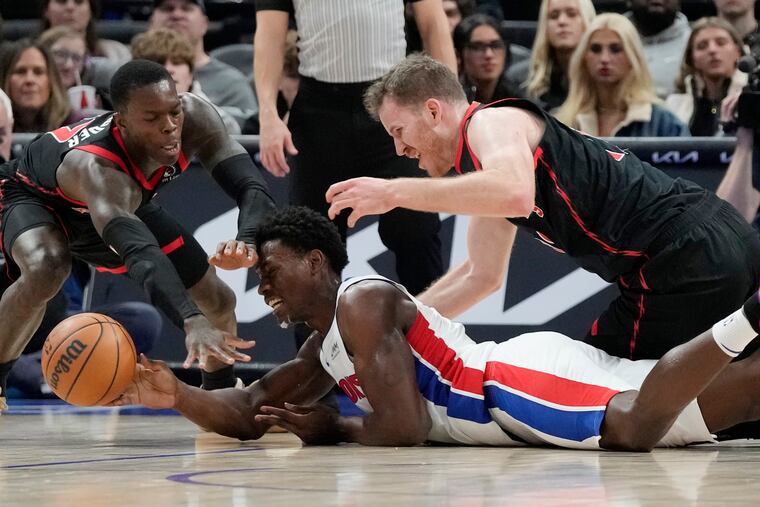Toronto Raptors guard Dennis Schroder, left, and center Jakob Poeltl (19) reach in on Detroit Pistons center Jalen Duren during the first half Saturday.