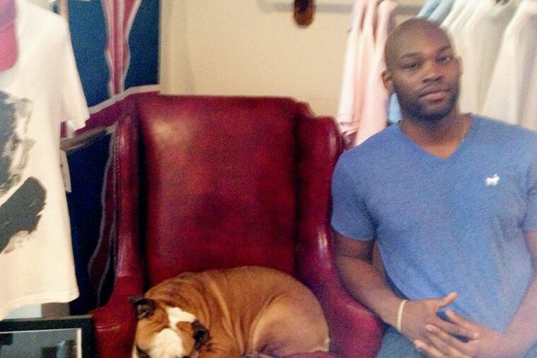 Seun Olubodun, of casual-fashion line Duke & Winston, with his English bulldog, Duke, next to a photo of Sir Winston Churchill.