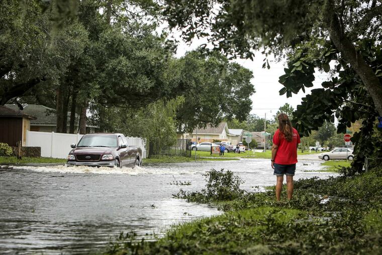 A truck drives through the flooded Town & Country Drive in Kissimmee, Fla., on Monday.