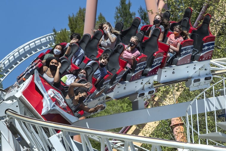 People riding the Revolution roller coaster, the world's first looping roller coaster, at Six Flags Magic Mountain in Valencia on the second day that the park reopened after more than a year of being closed due to the coronavirus outbreak.