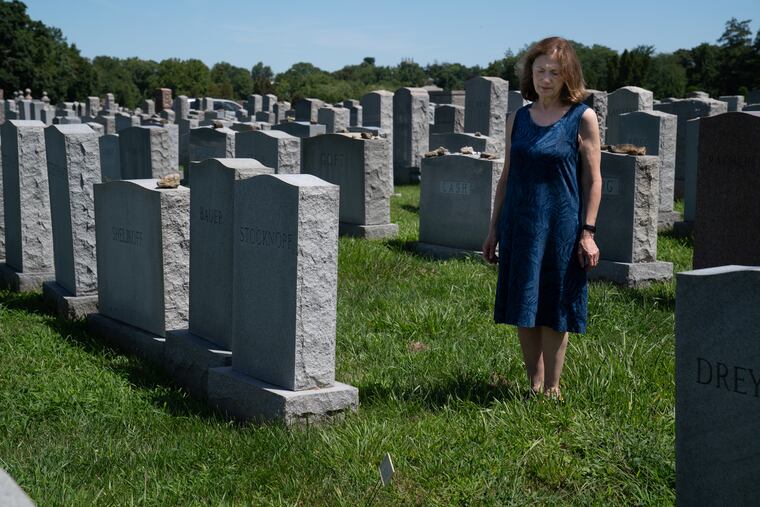 Linda Freimark stands Thursday at Montefiore Cemetery in Jenkintown, where her father, Jerry Freimark, is buried. There is a small temporary marker on her fathers grave, and a space where the monument should be.