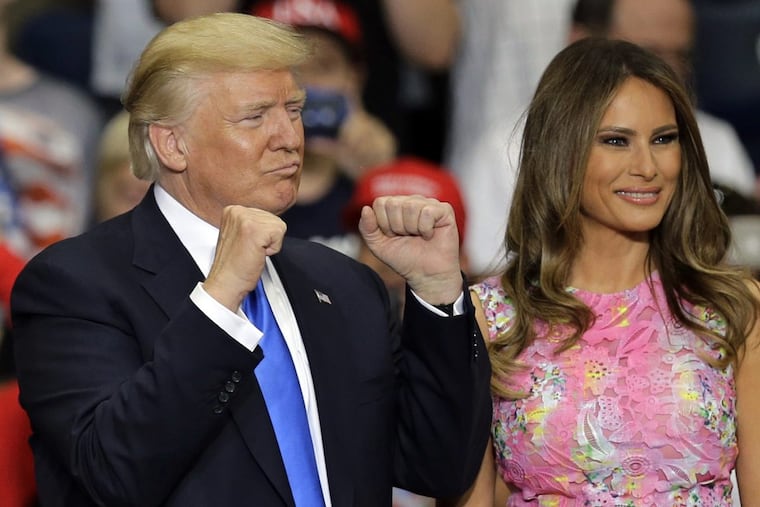 President Trump pumps his fists before speaking at the Covelli Centre, in Youngstown, Ohio, on Tuesday, accompanied by his wife, Melania.
