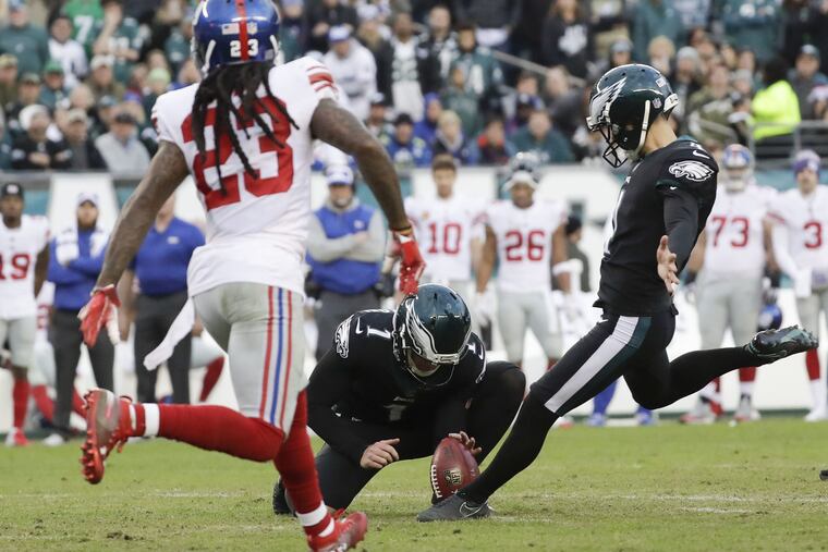 Jake Elliott kicks the game-winning field goal as Giants cornerback B.W. Webb tries to catch him.