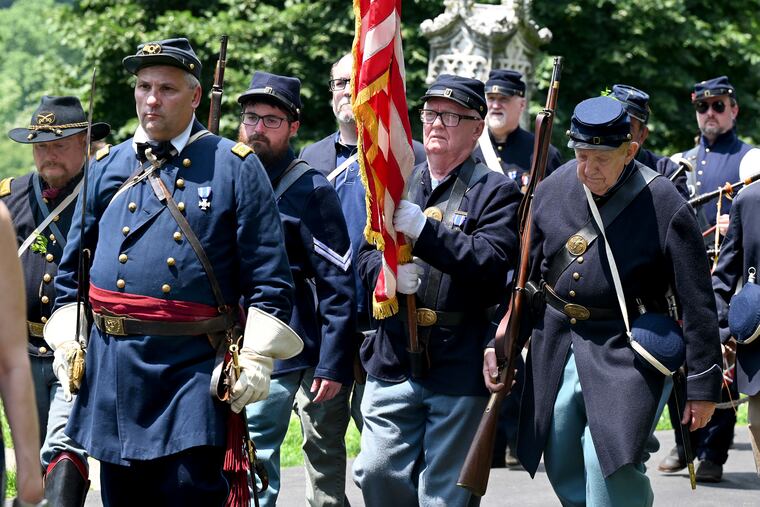 A color guard made up of members of various local Civil War reenactment units marches between ceremonies at the cemetery.