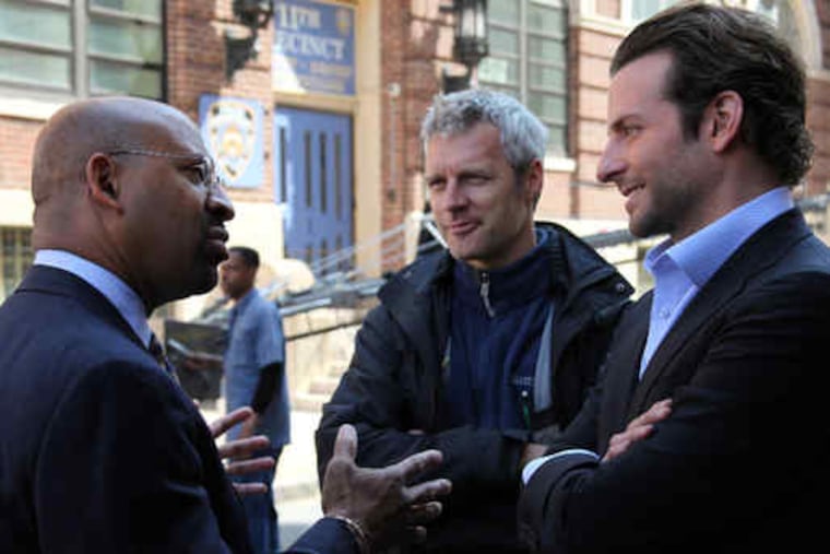Neil Burger, director of "The Dark Fields," says Philadelphia has "the energy that only a few big metropolises have." Above, Burger (center) with Mayor Nutter and actor Bradley Cooper. At left, in front of a makeshift NYPD precinct at 19th and Wood Streets. (See "At the movies.")