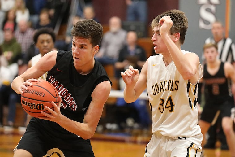 Haddonfield's Ben Cerrato (left) collects a rebound as Moorestown's Kevin Muhic looks on.