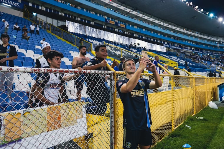 After the Champions League game at Alianza on Tuesday, Mikael Uhre (right) posed for a photo with some Union fans who traveled to the game.