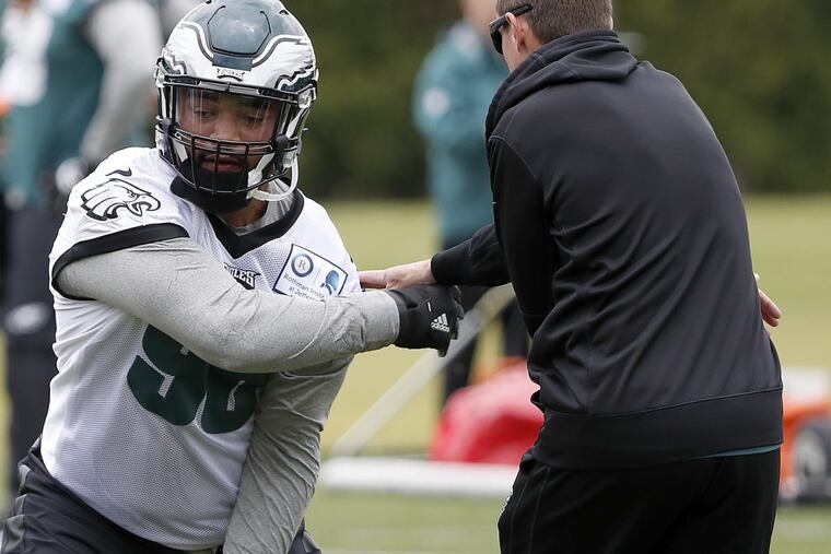 The Eagles’ Derek Barnett (left) works with coach Dave Fipp during rookie camp.