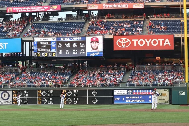 Aaron Nola (left) stands on the mound as shortstop Scott Kingery, second baseman Cesar Hernandez and first baseman Carlos Santana employ a defensive shift against Bryce Harper on Tuesday.