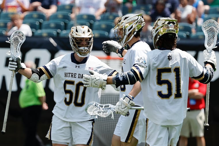 Notre Dame attackman Chris Kavanagh (left) celebrates with midfielder Will Angrick (center) and attackman Pat Kavanagh (51), his older brother.