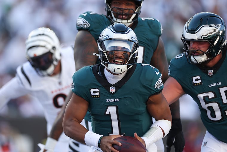 Jalen Hurts (1) celebrates with tackles Lane Johnson (right) and Fred Johnson after Hurts scored a fourth-quarter touchdown against the Cincinnati Bengals.