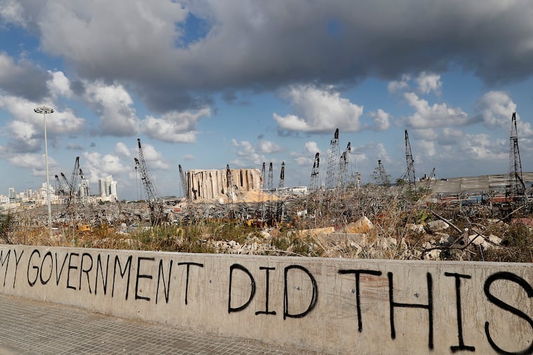 Words are written by Lebanese citizens in front of the scene of Tuesday's explosion that hit the seaport of Beirut, Lebanon, Sunday, Aug. 9, 2020. Public fury over the massive explosion in Beirut took a new turn Saturday night as protesters stormed government institutions and clashed for hours with security forces, who responded with heavy volleys of tear gas and rubber bullets.