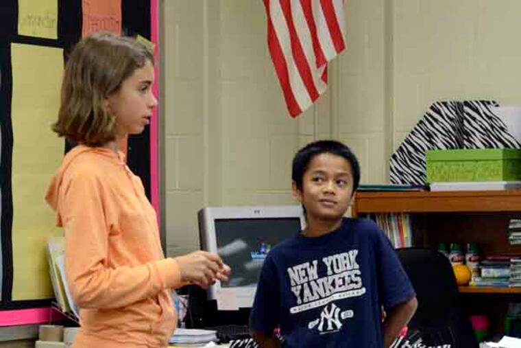 Sixth graders Sarah Trefz (left) and Kyaw Kyaw give a presentation before their classmates in teacher Natalie Rosati's class at the Oaklyn School October 17, 2013. Kyaw is one of the fourteen kids from Myanmar (formerly known as Burma) at the school. ( TOM GRALISH / Staff Photographer )