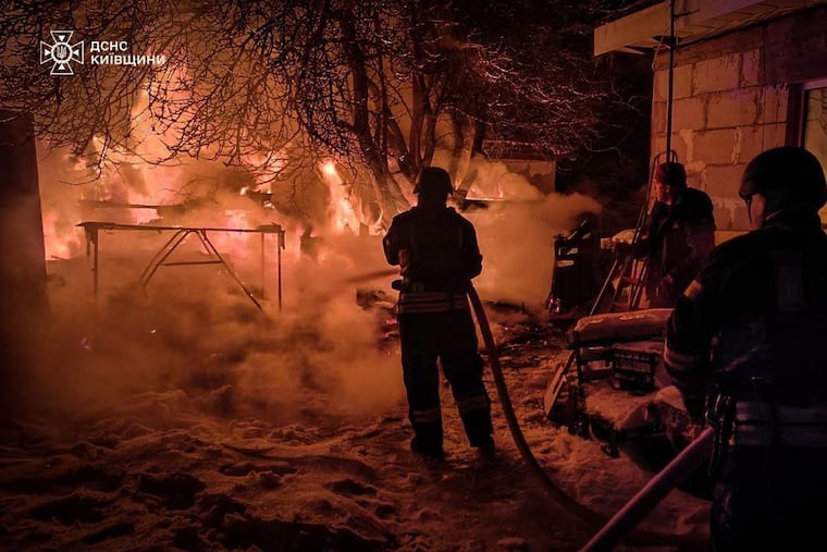 In this photo provided by the Ukrainian Emergency Service, first responders work to extinguish a fire following a Russian attack in Ukraine's Kyiv region on Tuesday.