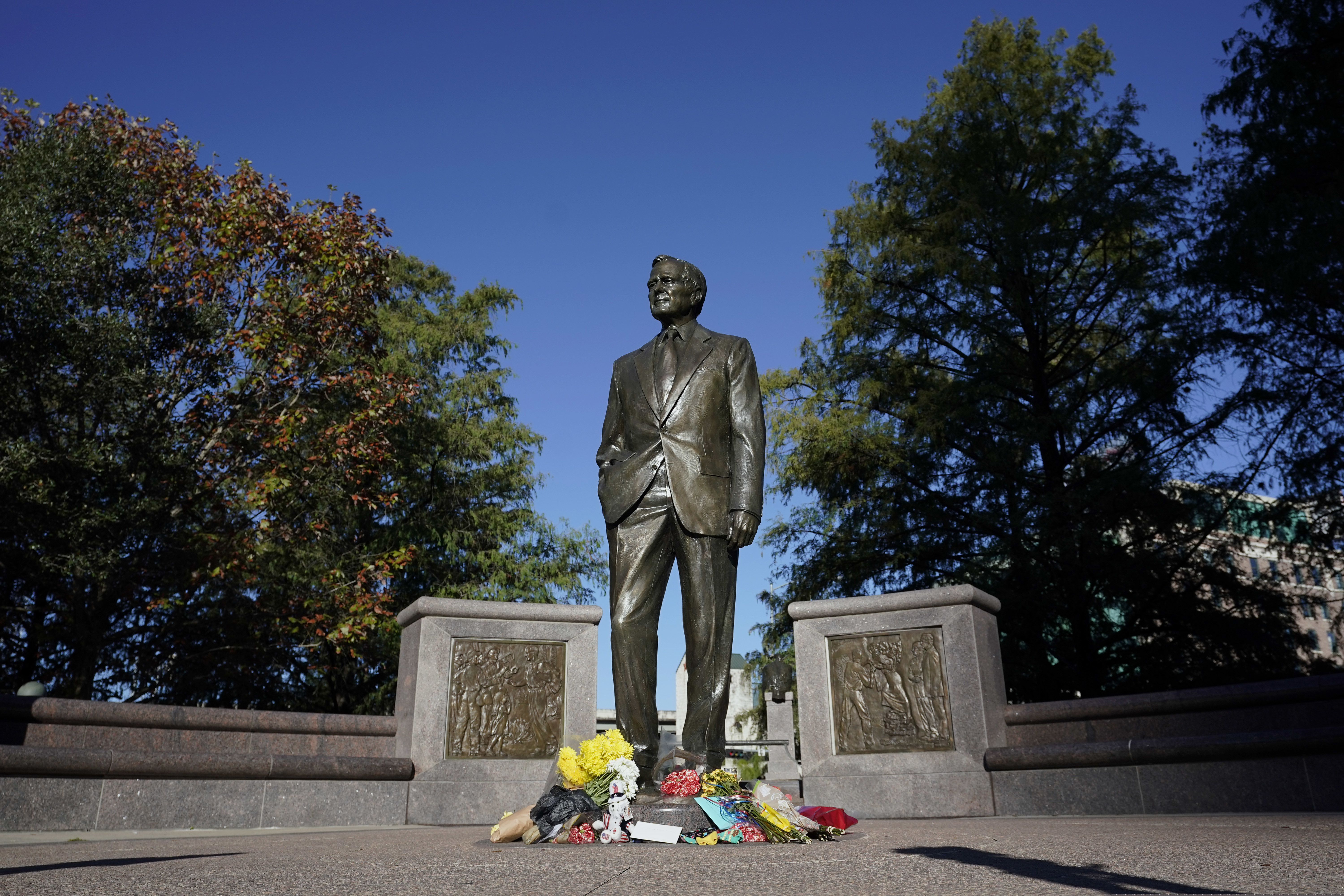 A makeshift memorial sits at the base of a statue of former President George H.W. Bush in downtown Houston on Sunday.