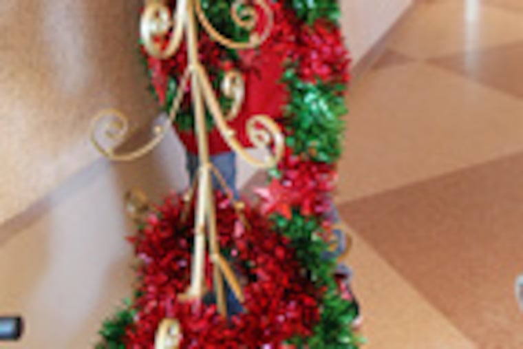 Alyssa Gogel, 15, of Chalfont, is entwined in tinsel as she undresses a metal Christmas tree after the church dinner.