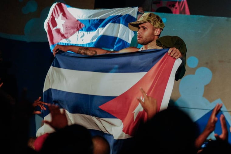 In this April 23, 2010, photo, Cuban singer Bian Rodriguez, member of the Los Aldeanos, holds a Cuban flag as they play in concert at the Acapulco Theatre in Havana, Cuba. (AP Photo)