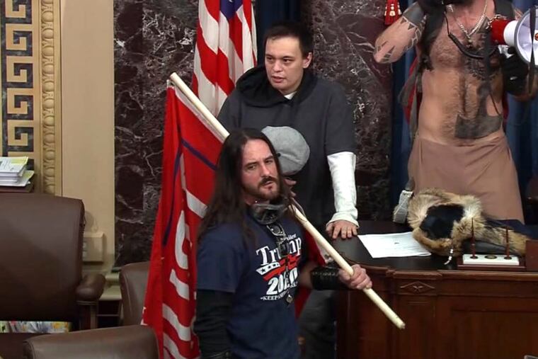 In this image from U.S. Capitol Police video, Paul Allard Hodgkins (front) stood in the well on the floor of the U.S. Senate on Jan. 6 at the Capitol in Washington.