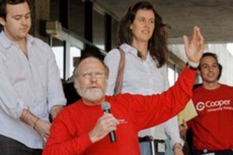 Gov. Corzine acknowledges cheers as son Jeffrey and his daughter, Jennifer Corzine Pisani, push his wheelchair out of Cooper University Hospital in Camden. He still faces a long recovery.