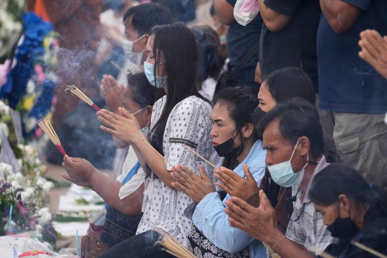 Relatives of the victims of a mass killing attack gather for a Buddhist ceremony in front of the Young Children's Development Center in the rural town of Uthai Sawan, north eastern Thailand, Sunday, Oct. 9, 2022.