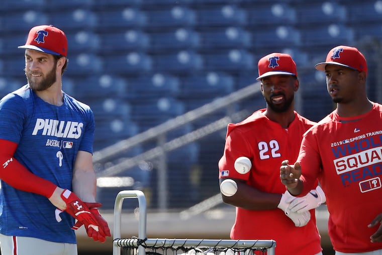 Bryce Harper with new Phillies teammates Andrew McCutchen and Jean Segura after they finished batting practice during spring training.