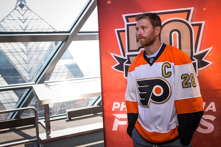 Flyers captain Claude Giroux shows off the 50th anniversary commemorative jersey. It has gold accents to mark their years as a team.