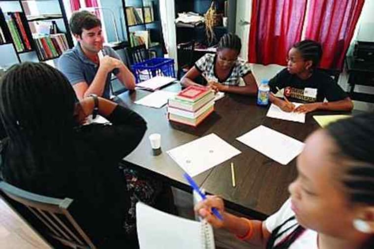 Writing coach Eric Carlan (second from left) oversees workshop at Mighty Writers.