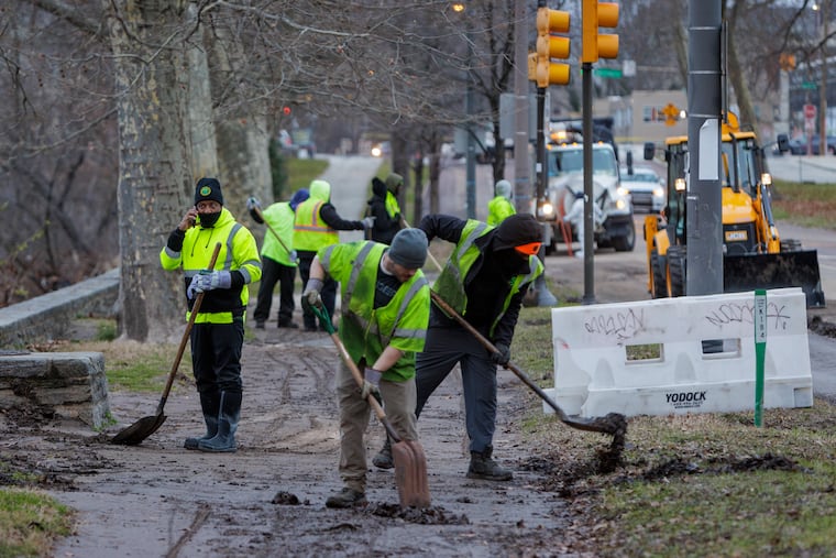 Philadelphia Streets Department employees on Kelly Drive near Midvale Avenue, clearing the roadway of mud after flood water went over bank of Schuylkill River.