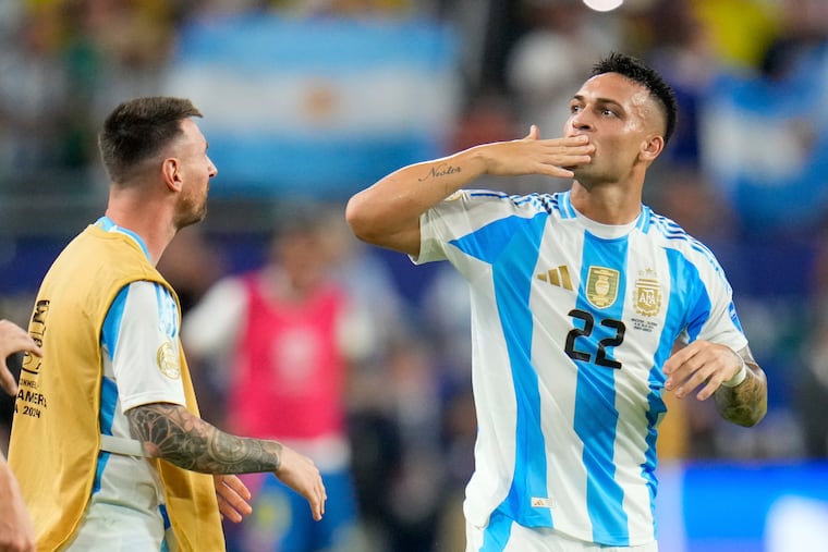 Argentina's Lautaro Martínez (22) celebrates with Lionel Messi after scoring his side's opening goal against Colombia during the Copa America final soccer match on Sunday in Miami Gardens, Fla.