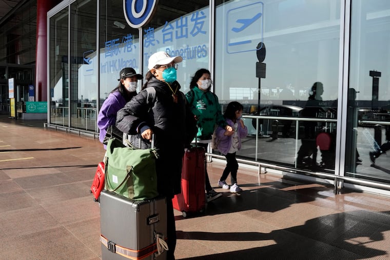 Passengers wearing masks walk through the Capital airport terminal in Beijing in mid-December.
