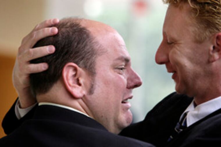 Patrolman John Gillespie (left) hugs fellow Deptford officer Brian Green after being acquitted of assault.