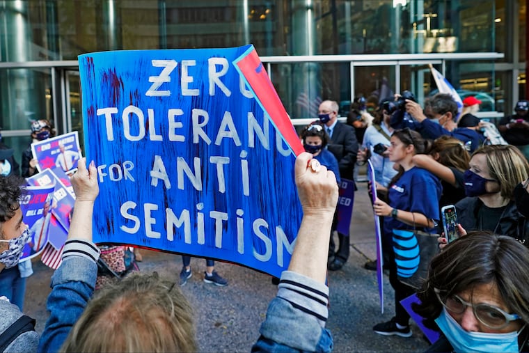 A woman holds a sign as she and others protest outside the offices of New York Gov. Andrew Cuomo, Thursday, Oct. 15, 2020, in New York.